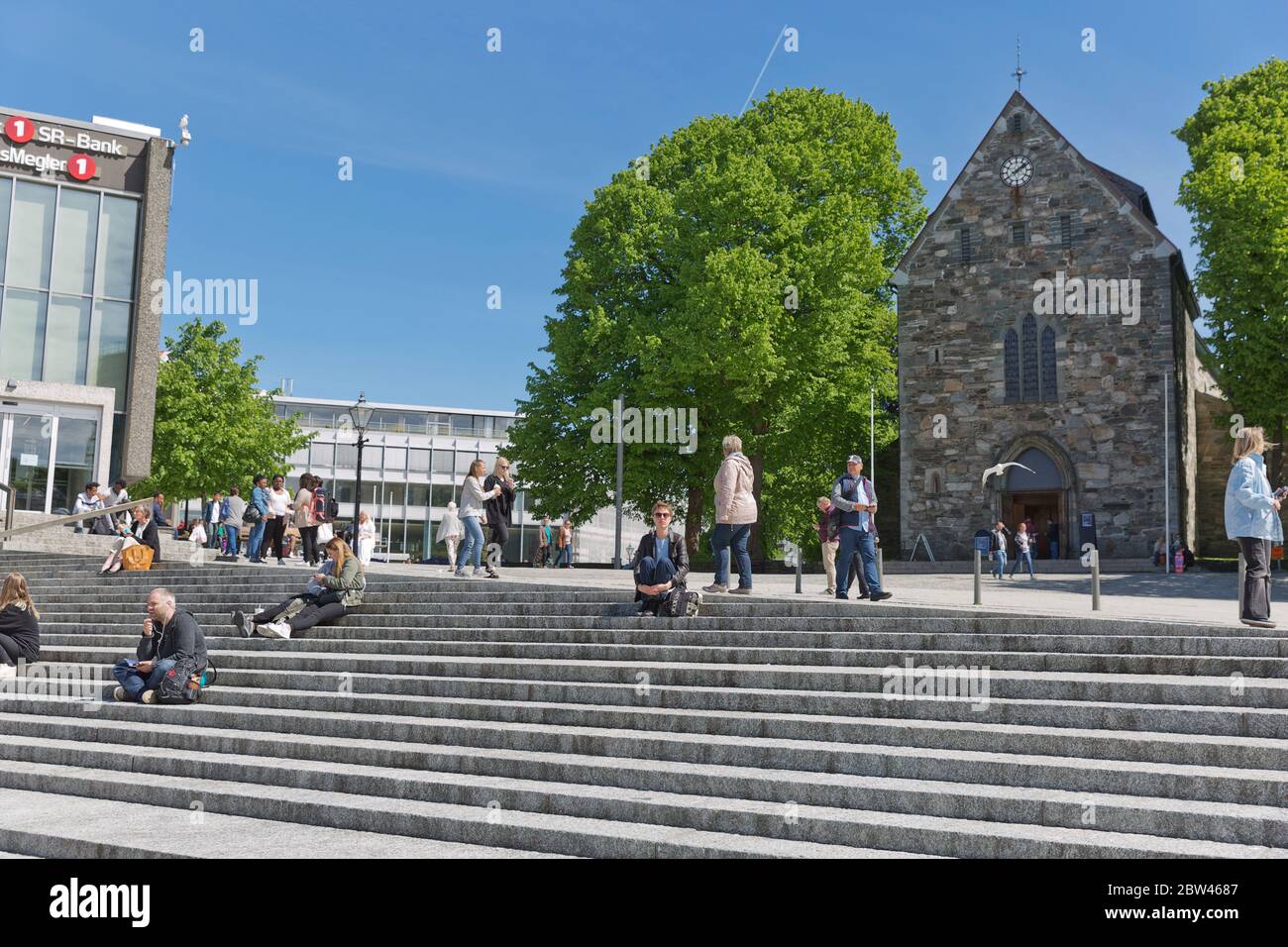 STAVANGER, NORWAY - JUNE 01, 2017: People relaxing and sitting on stairs in front of Stavanger Cathedral in Stavanger Norway. Stock Photo