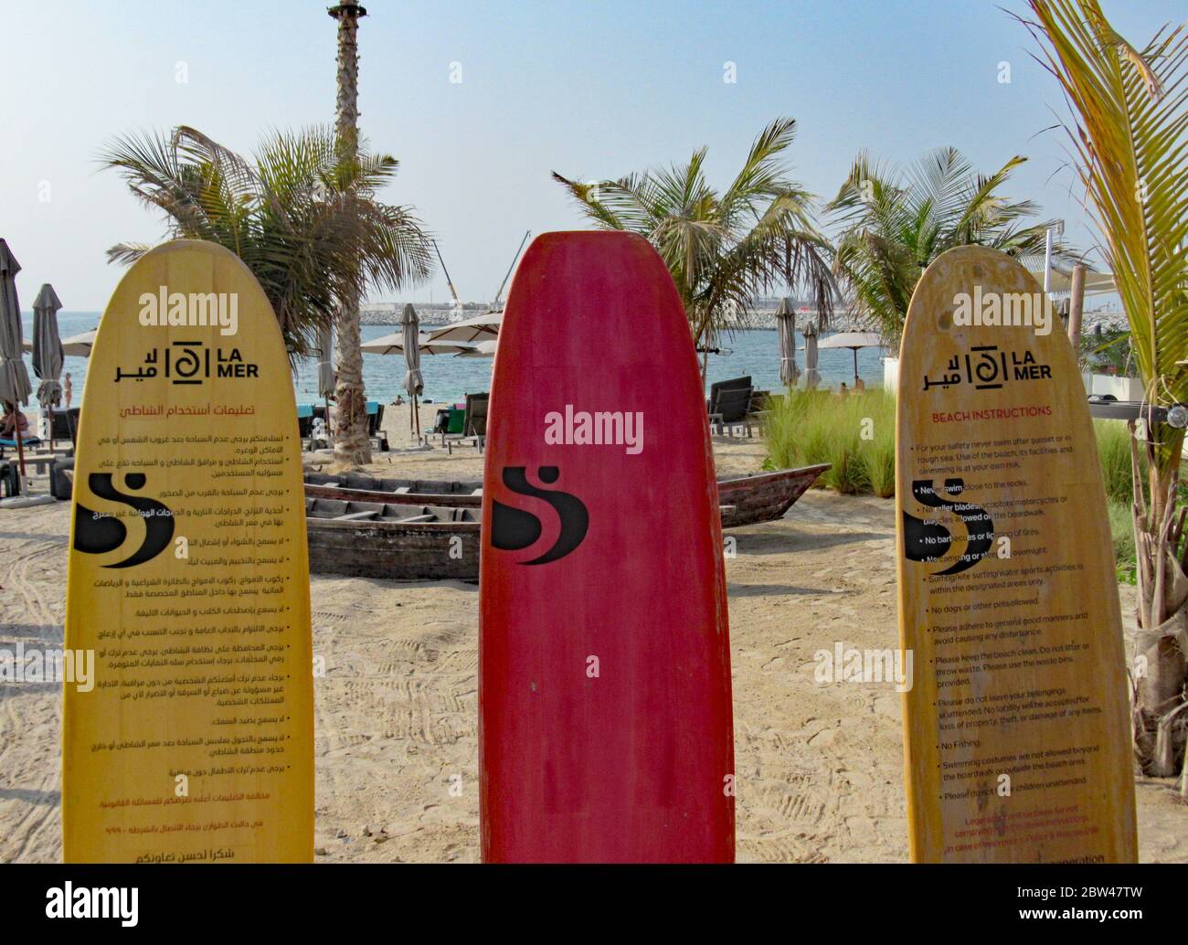Three surfboards on the beach in Dubai showing safety instructions in