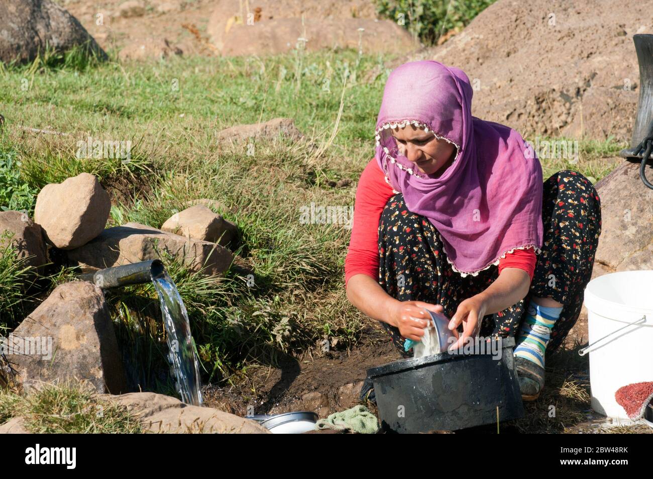Asien, Türkei, Provinz Bingöl, Frau vom Stamm der Beritan-Nomaden beim Waschen von Töpfen und Geschirr auf einer Hochweide in den Serafettin-Bergen ös Stock Photo