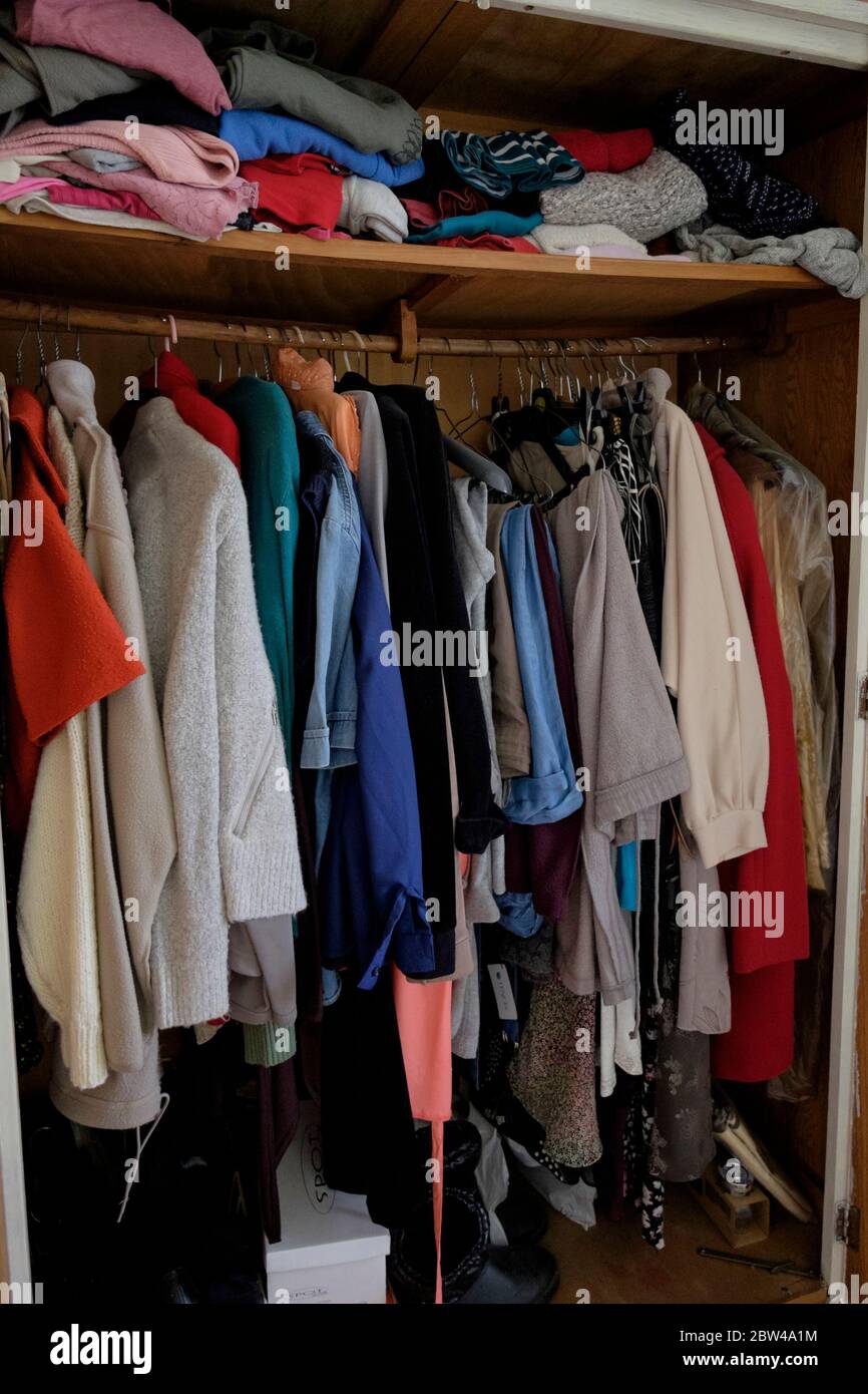 Clothes hanging in wardrobe belonging to a recently deceased elderly woman, UK. Stock Photo
