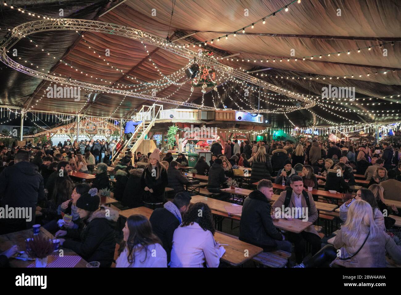 Crowds in a German beer tent and Bavarian beer hall at the Bavarian Village, Winter Wonderland, Hyde Park, London, UK Stock Photo