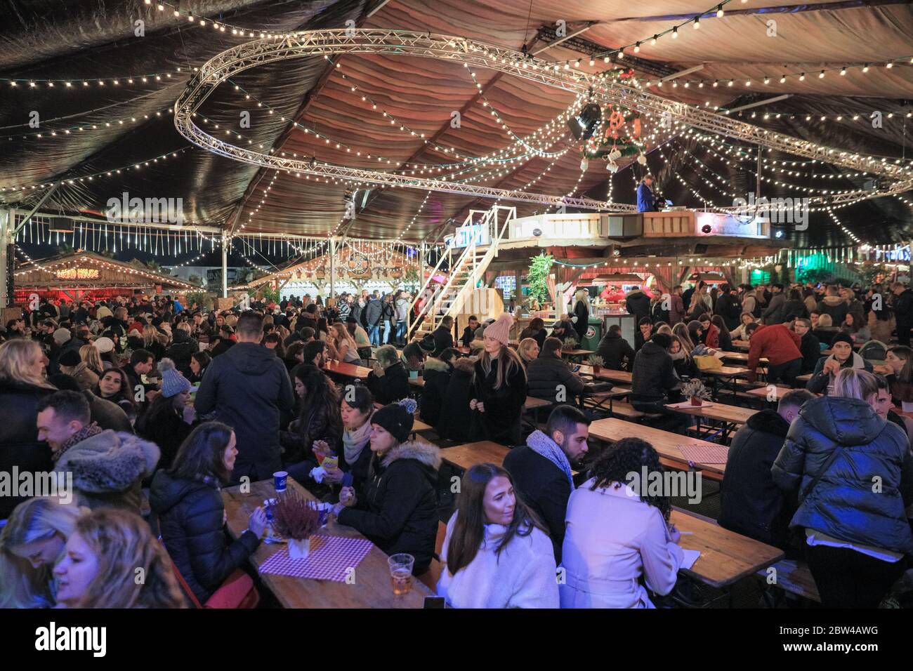 Crowds in a German beer tent and Bavarian beer hall at the Bavarian Village, Winter Wonderland, Hyde Park, London, UK Stock Photo