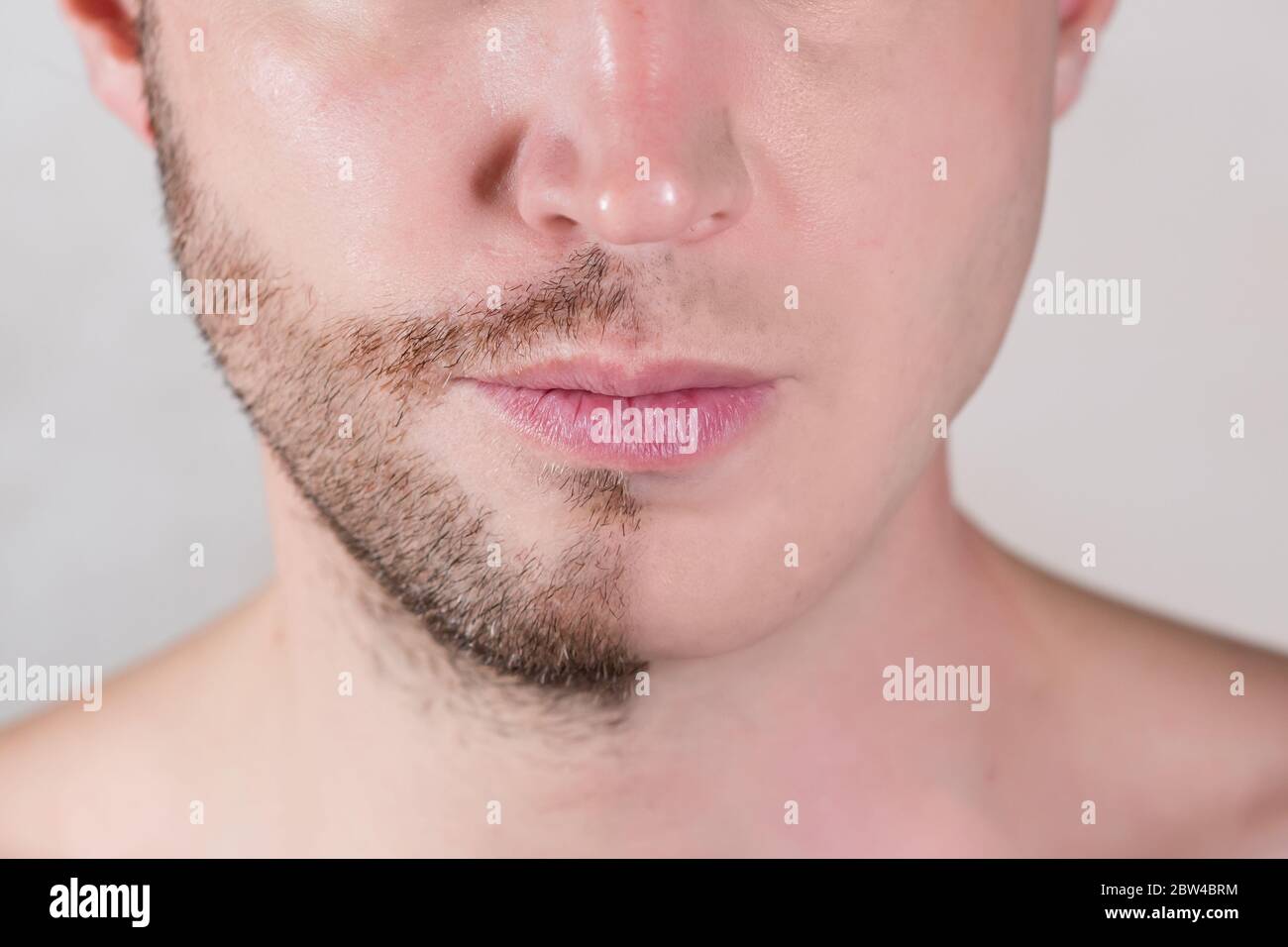 the lower half of the man s face is only half shaved Stock Photo