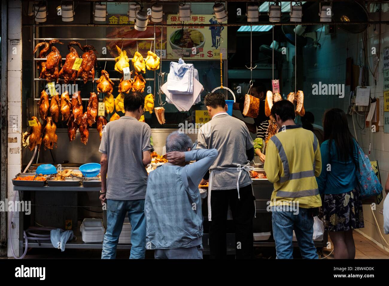 Hong Kong - November, 2019: People buying roasted ducks, peking duck and roast goose, on street food market in Hong Kong Stock Photo
