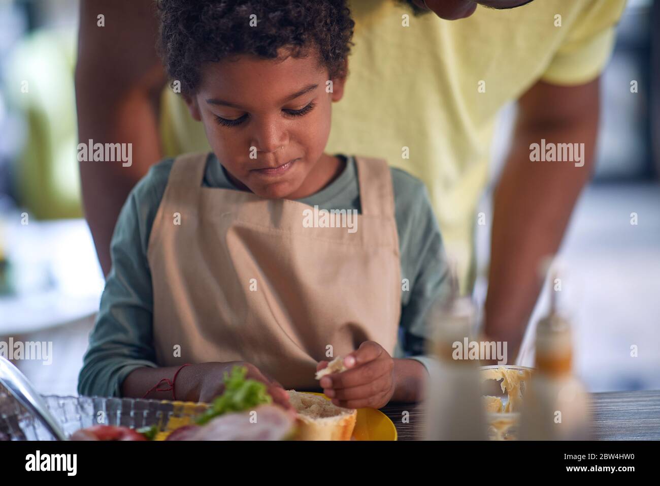 Afro American cute boy having breakfast at home. Stock Photo