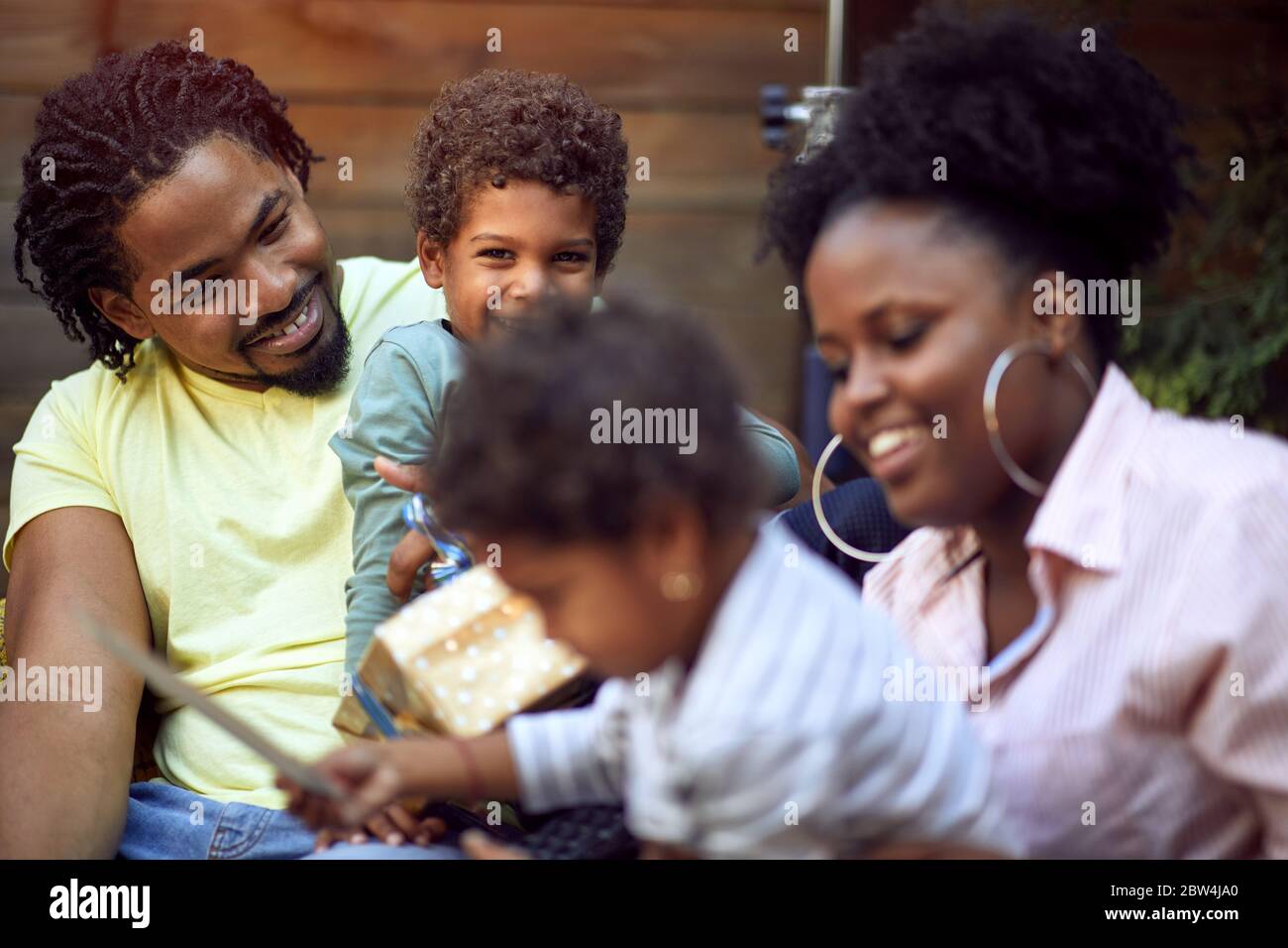 Happy Afro-American young family enjoying together outdoor at birthday party. Stock Photo