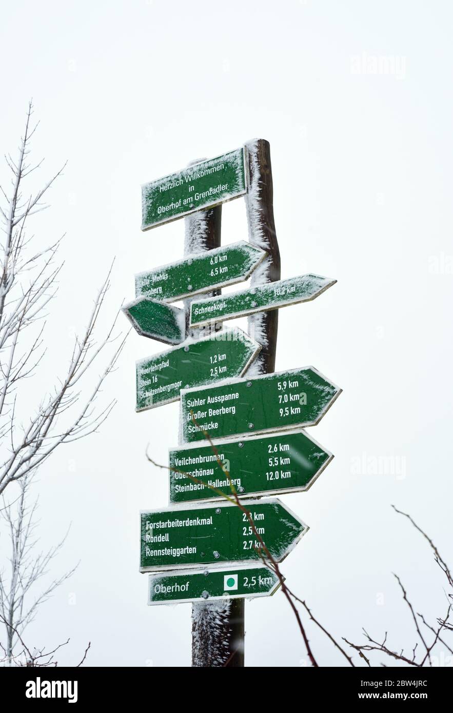 Oberhof, Germany 21-14-2019 wooden signs of hiking paths covered with snow indicates directions, mountains, villages around the Rennsteig area in the Stock Photo