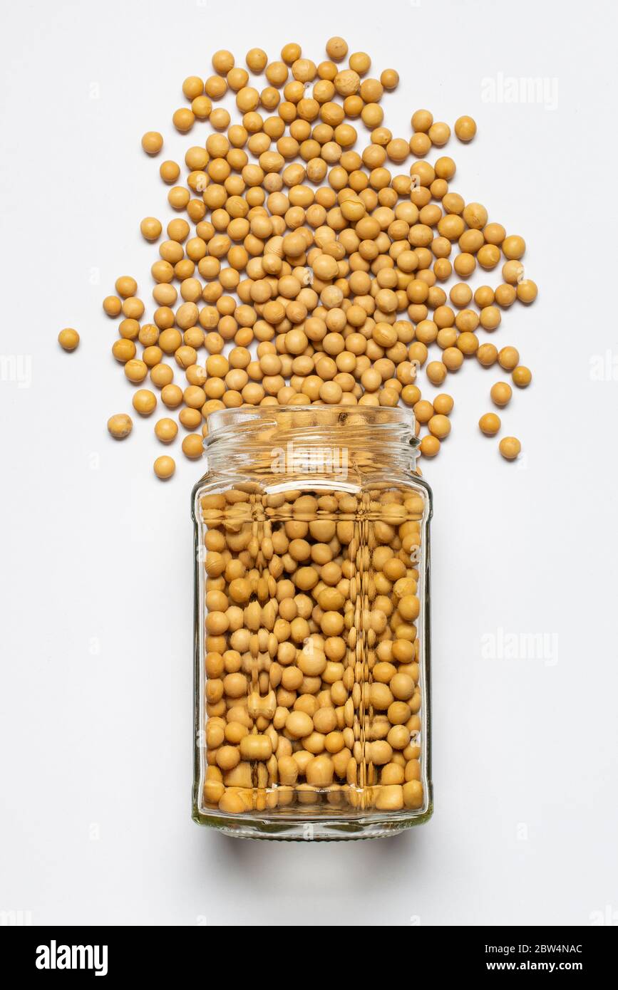 glass jar with yellow soybean in the foreground, top view, isolated from the white background