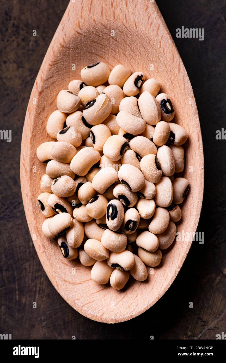 View from above, in the foreground, a spoonful of beans with the eye, a typical Italian legume of ancient tradition. Stock Photo