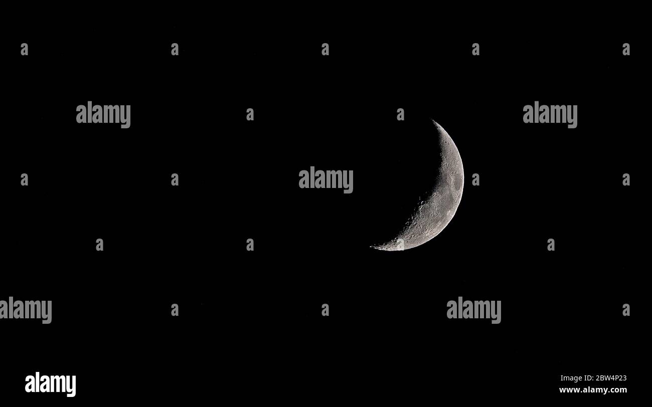 Waxing Crescent Moon and dark sky Stock Photo
