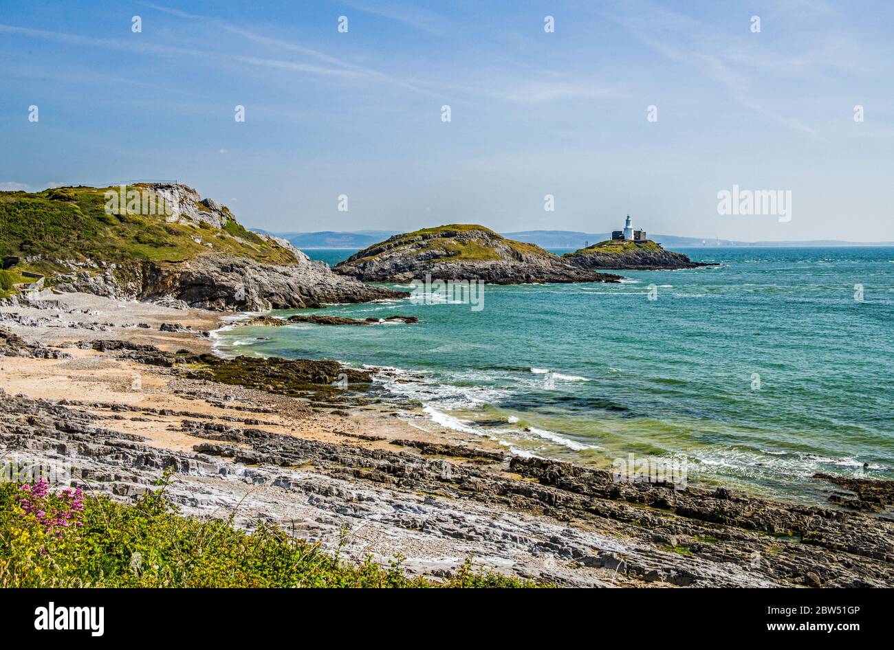 Bracelet Bay on a sunny Spring day in May. Bracelet Bay is in the south of  the Gower Peninsula near Swansea, south Wales. The lighthouse is the Mumble  Stock Photo - Alamy