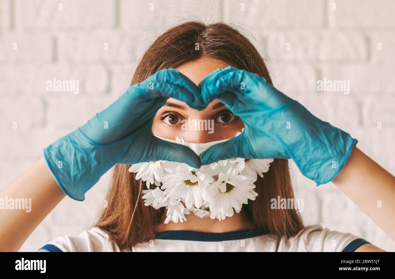 Portrait young woman doctor in medical face mask with flowers and ...