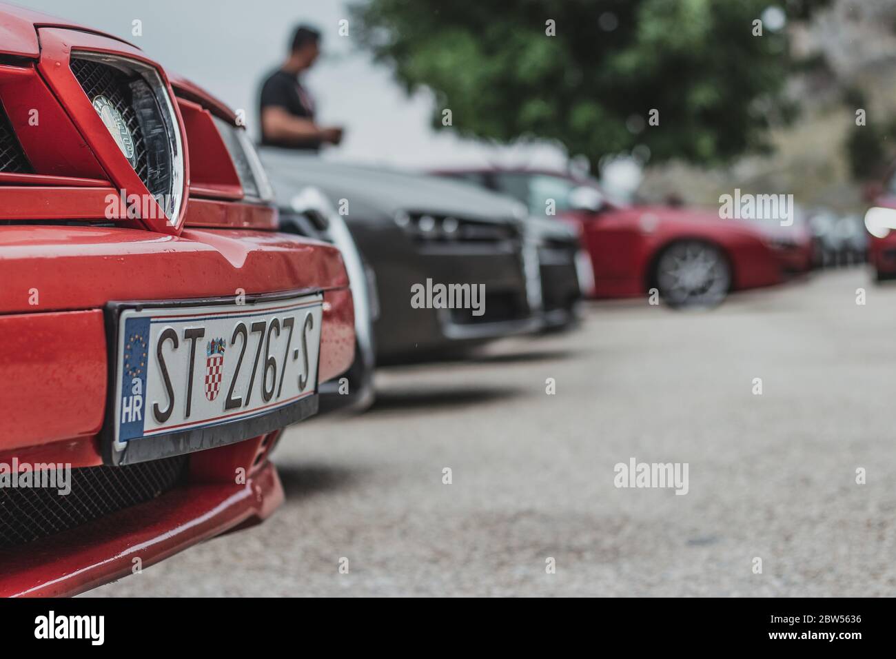 Front end and license plate of an Alfa Romeo 155, parked in a row with multiple other Alfa Romeos, part of an exhibition Stock Photo