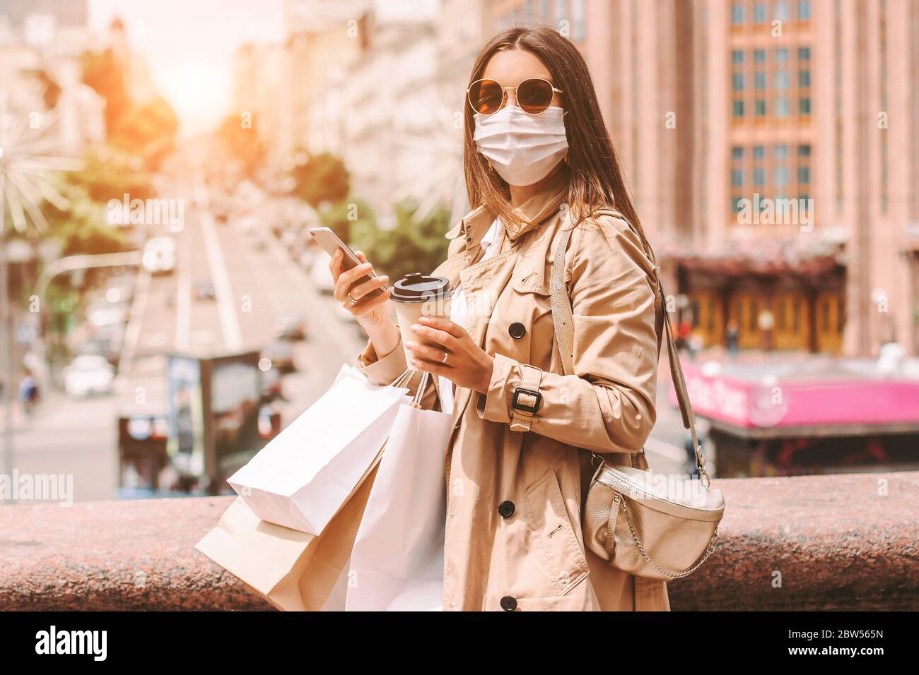 Beautiful young girl shopaholic in medical face mask and