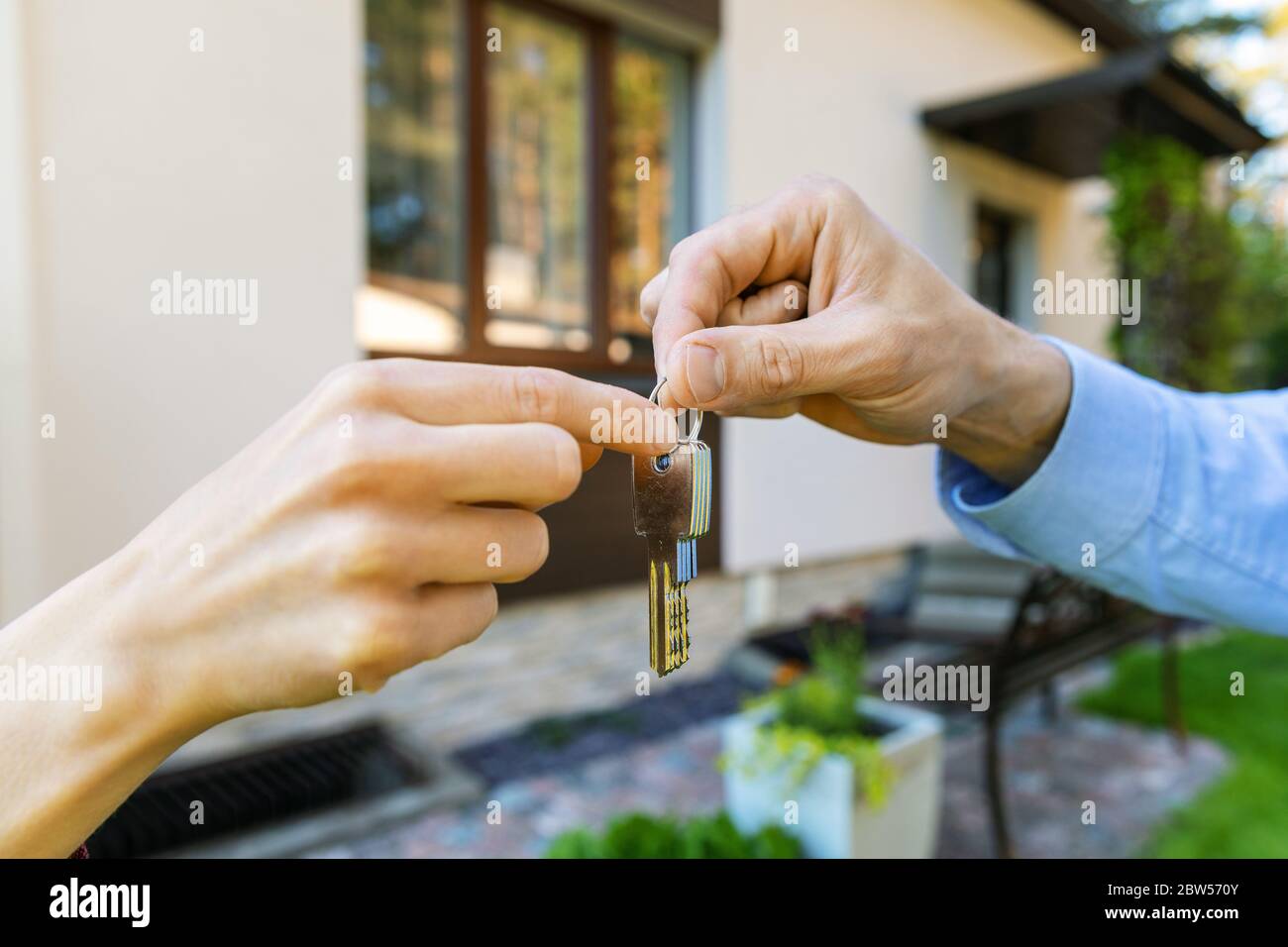 housing business - real estate agent giving new house keys to client Stock Photo
