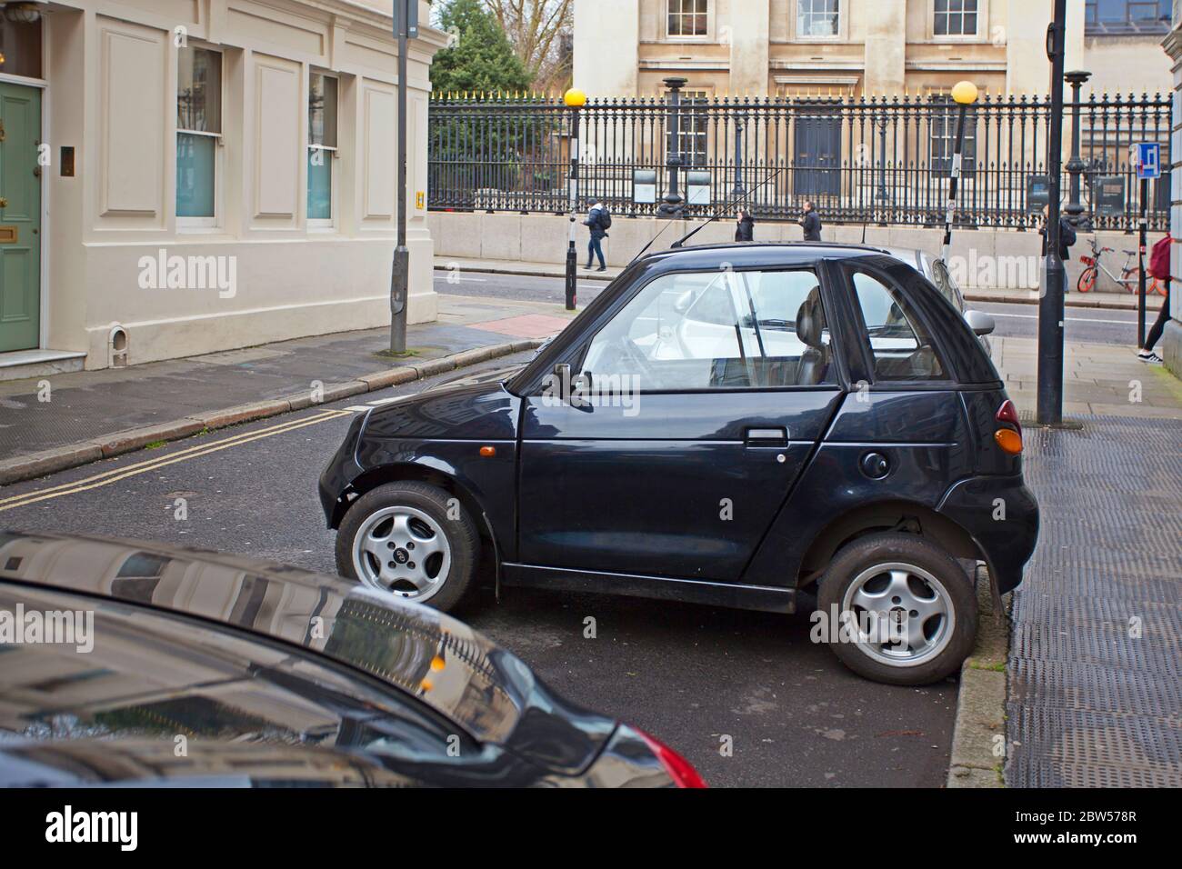 Very compact two door Reva G-Wiz car parked in a narrow alley in London Stock Photo