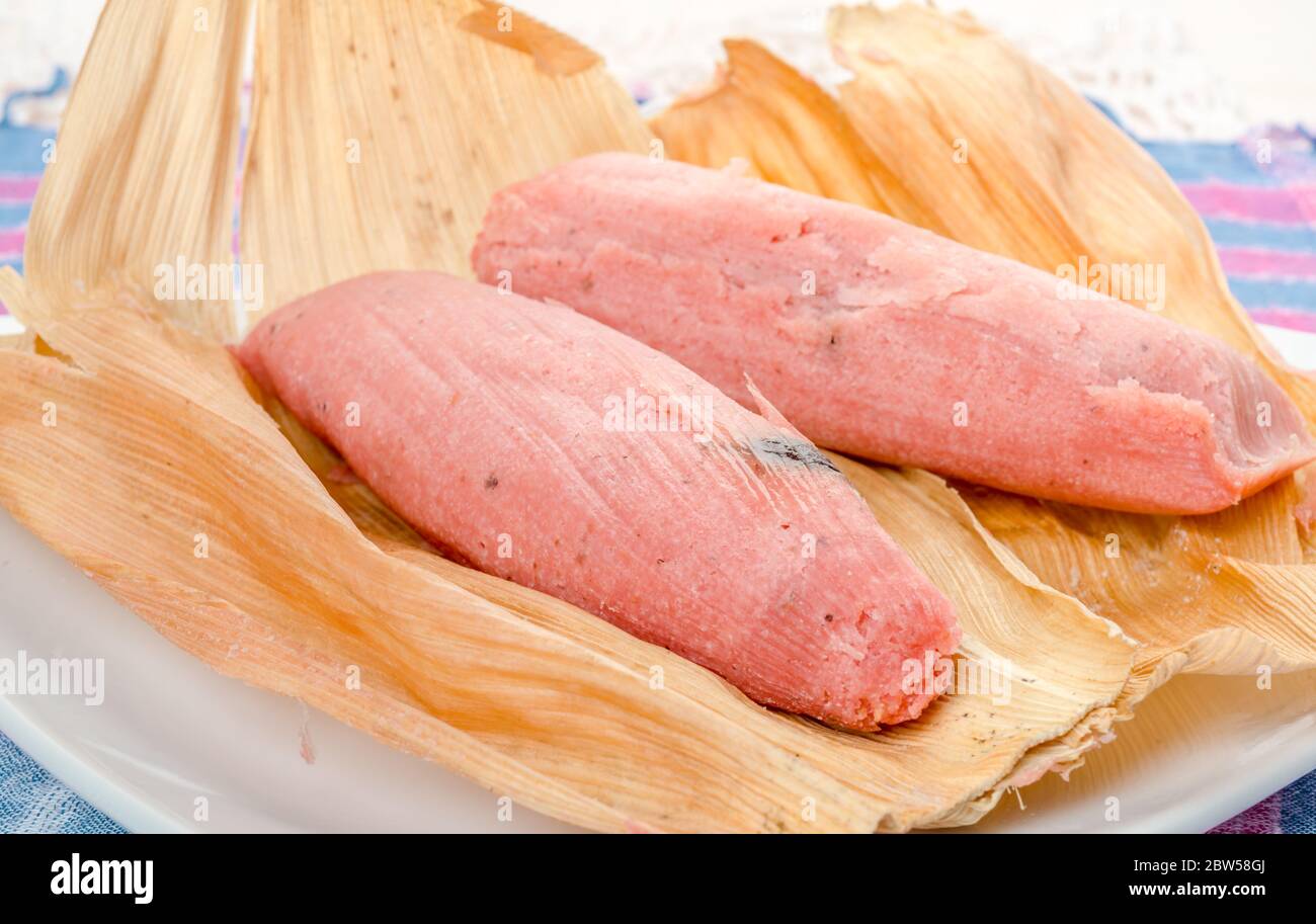 Sweet Tamale, Mexican dish made with corn dough with raisin and strawberry or pineapple flavored, wrapped with a corn leaf Stock Photo