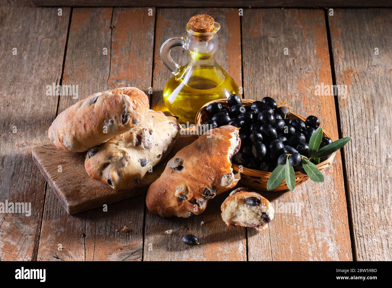 Traditional italian puccia breads with black olives on a cutten board with  olive oil and fresh black olives, made in Salento, Puglia Stock Photo -  Alamy