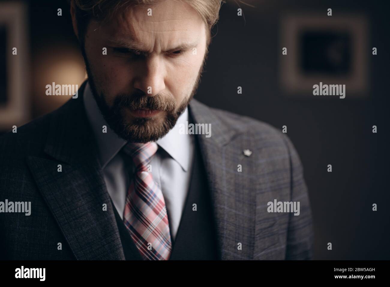 Thoughtful bearded man standing at modern office Stock Photo