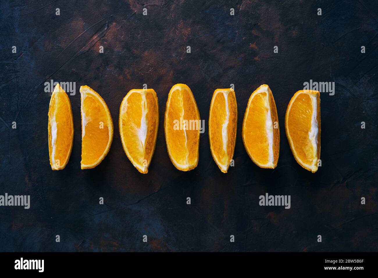 Seven Orange slices on a dark background.  Stock Photo