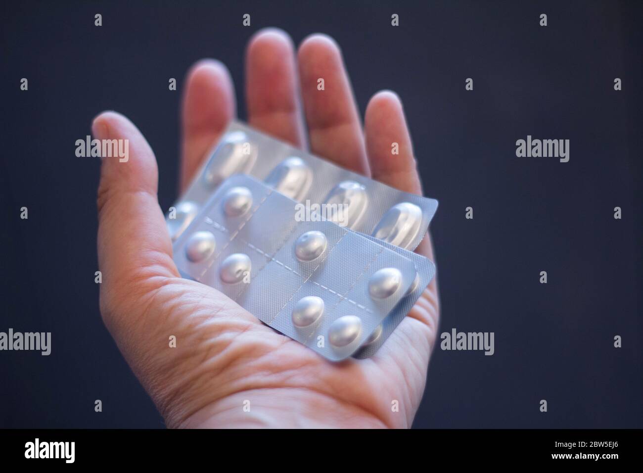 Outstretched hand holding a blister packs of pills. Stock Photo