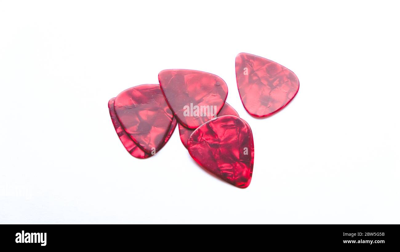 A group red guitar pics on a white background Stock Photo