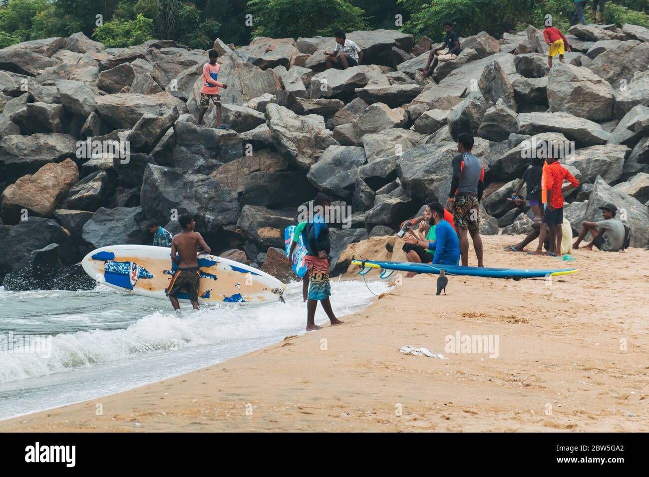 Surfers and surf school participants try to catch waves on