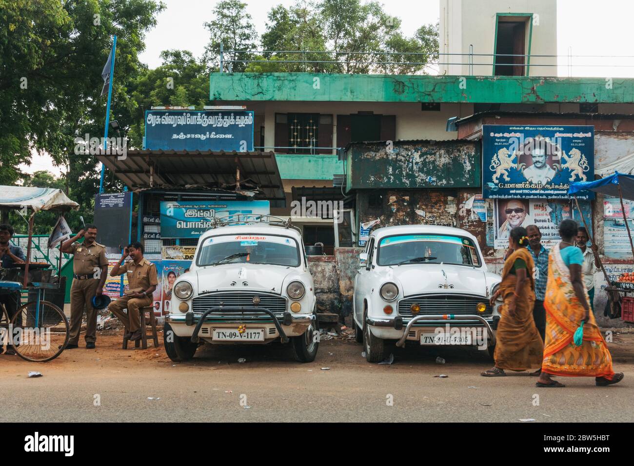 Two white Hindustan Ambassador cars parked on the roadside in Thanjavur, India Stock Photo