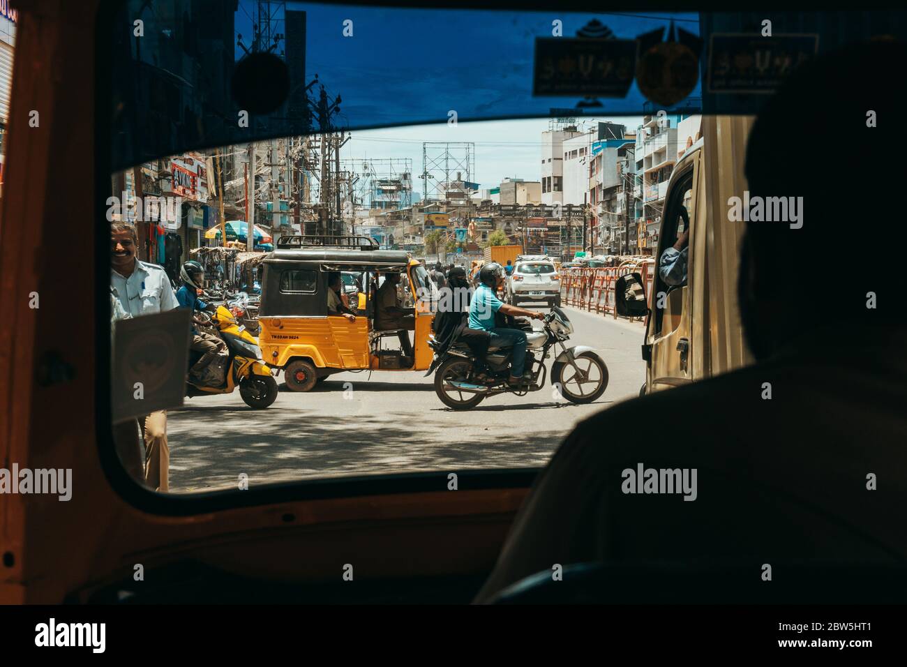 Traffic crosses at an intersection in Madurai, India. Seen from the passenger seat of an auto rickshaw Stock Photo