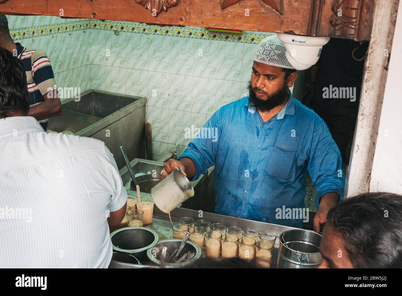 A man prepares glasses of a jigarthanda at a shop in Madurai, India