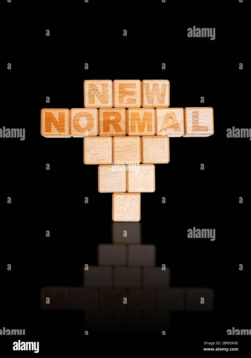NEW NORMAL word on engraved wooden alphabet cube blocks inverted in abnormal stack. Concept of new normal lifestyle after COVID-19 coronavirus pandemi Stock Photo