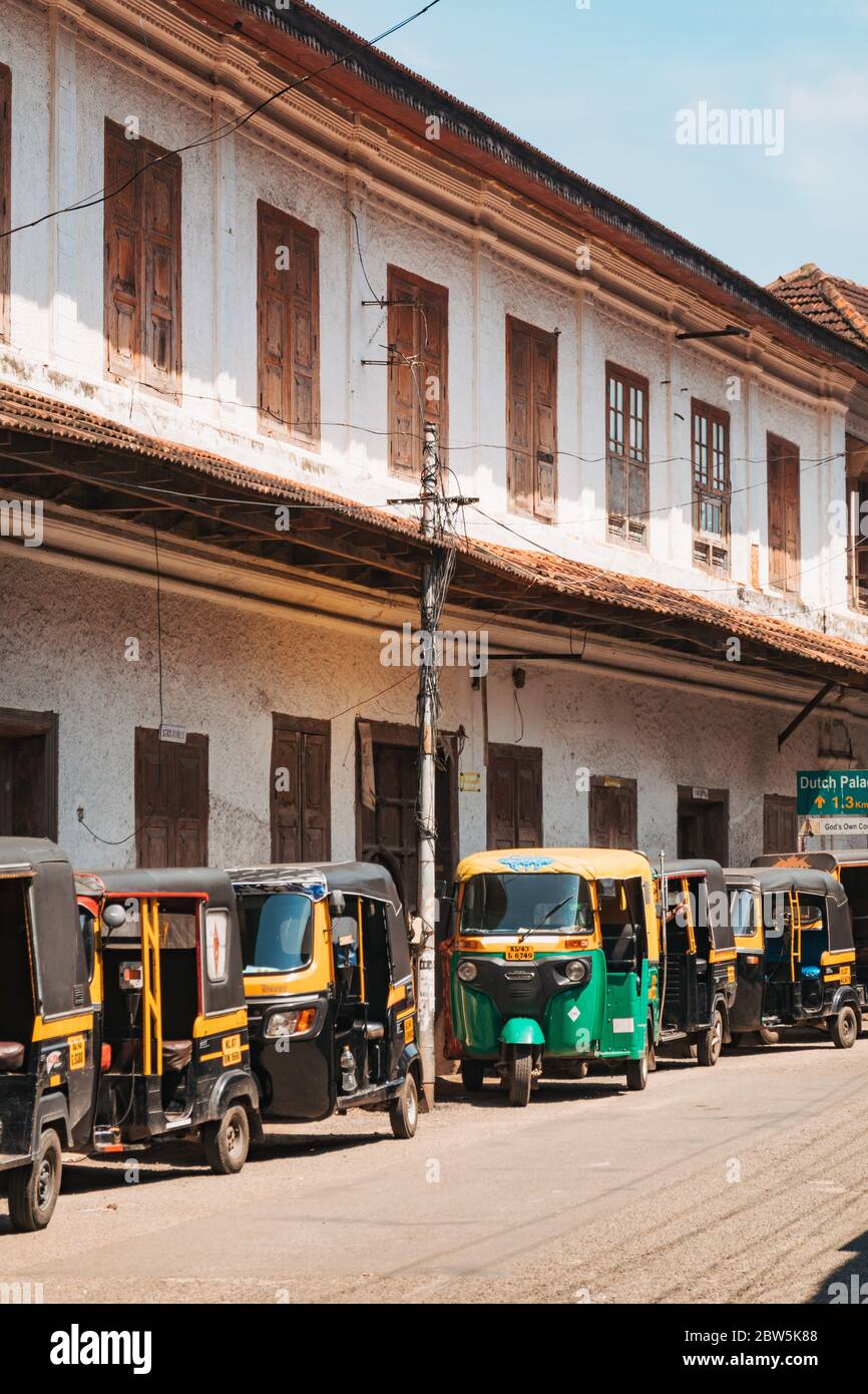 A row of auto-rickshaw taxis wait outside an old colonial Portuguese building in Mattancherry, Kochi, India Stock Photo