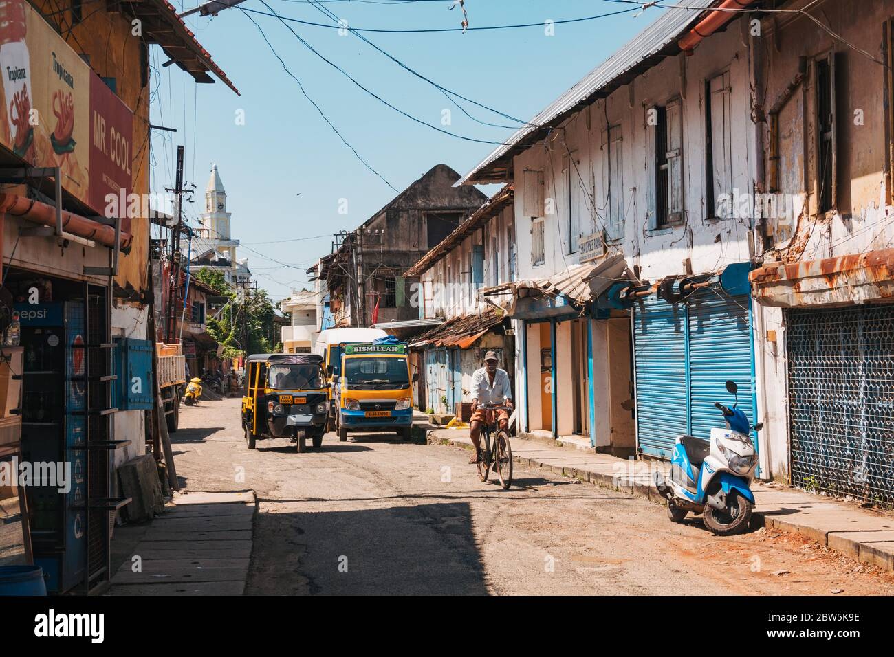 An auto-rickshaw taxi drives along a quiet street in Mattancherry, an area of Kochi with many colonial buildings still standing Stock Photo
