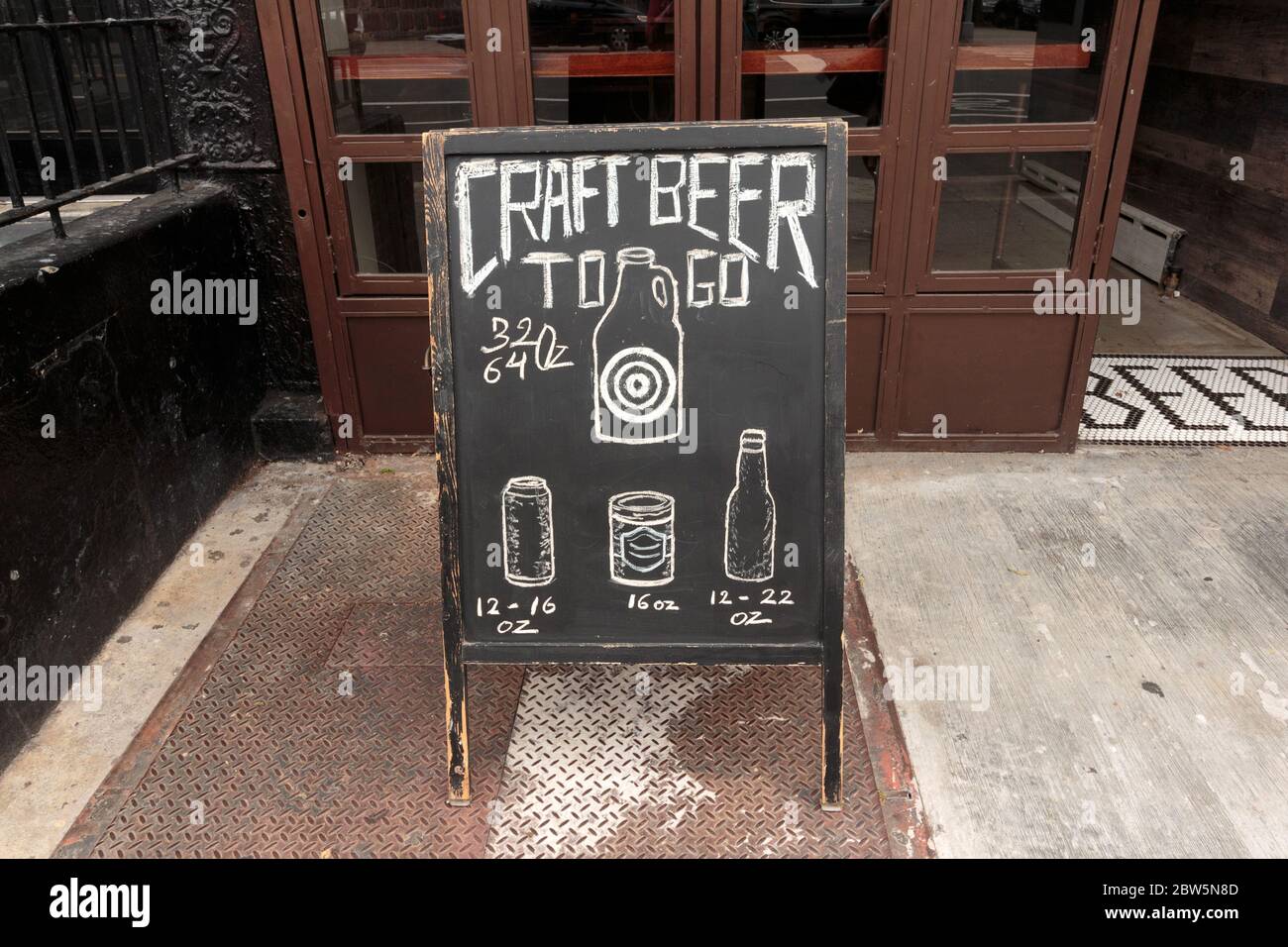 a sidewalk chalkboard or blackboard sign in Harlem advertising craft beer to go during the coronavirus or covid-19 pandemic Stock Photo