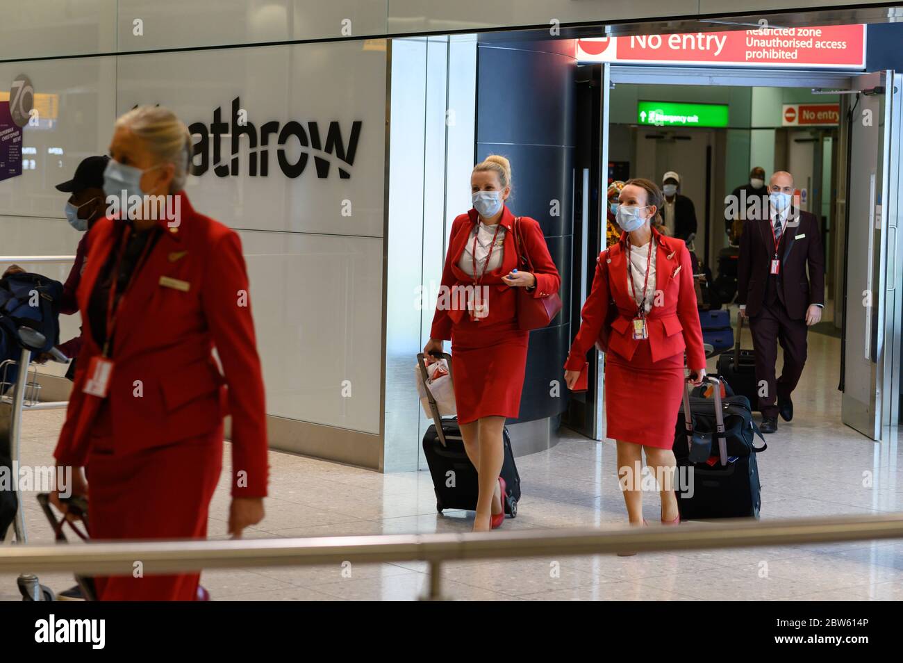 British passengers and flight attendants pushing luggage, arrive at