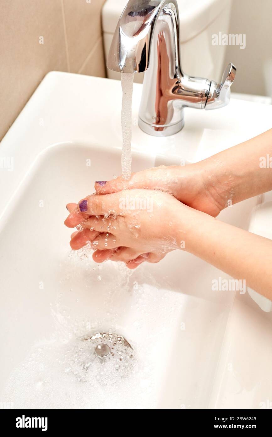 White Child Washing Hands with Soap and Running Water over Sink, Fingers Interlocked Stock Photo