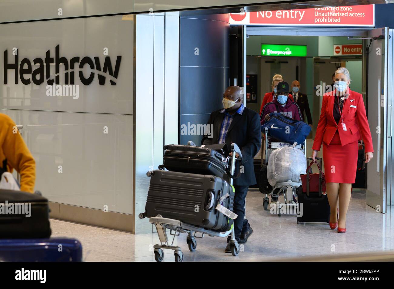 British passengers and flight attendants pushing luggage, arrive at