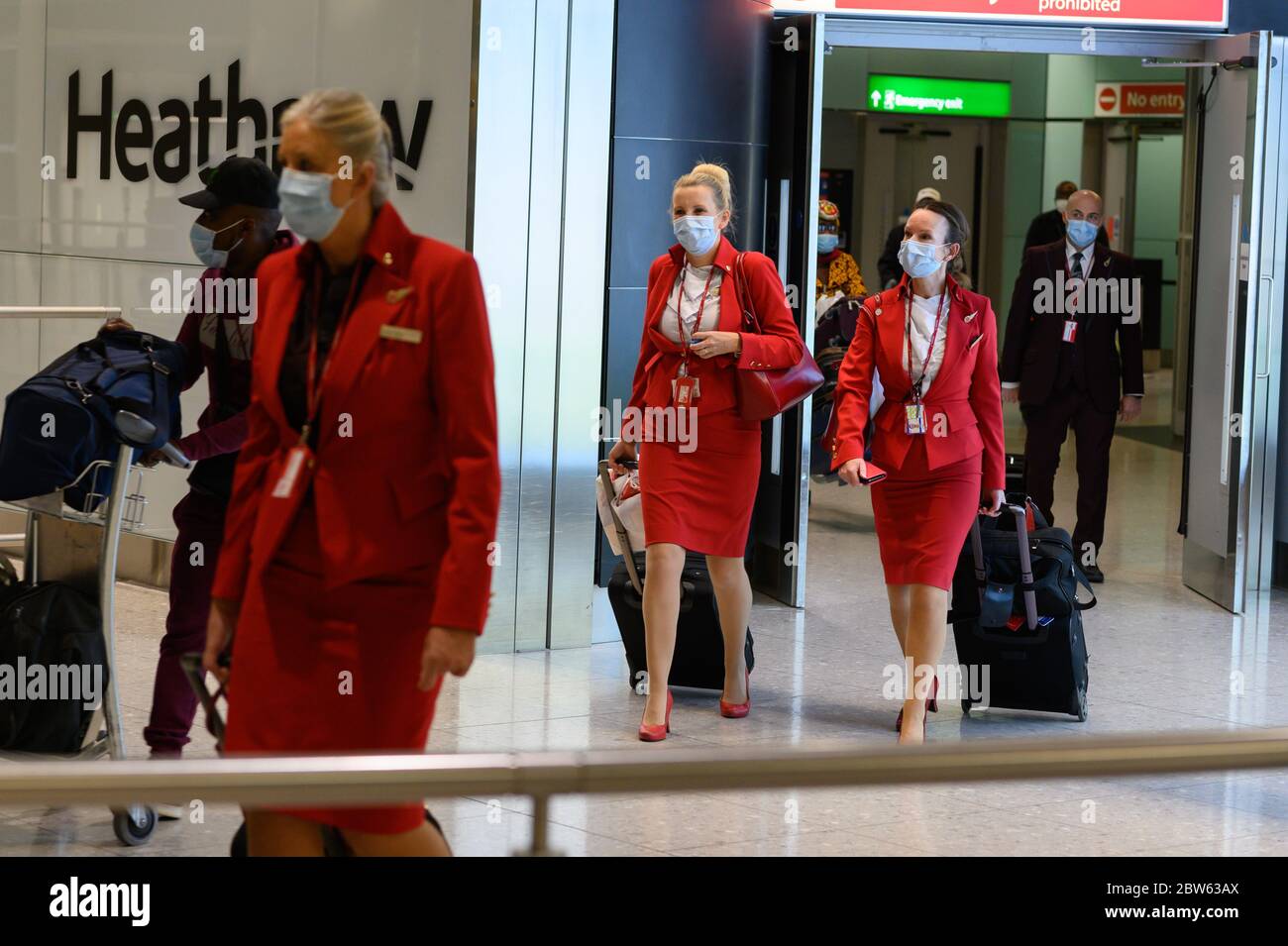 British passengers and flight attendants pushing luggage, arrive at