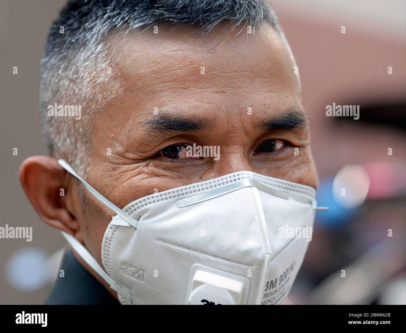Royal Thai police officer wears a protective face mask with breathing valve. Stock Photo