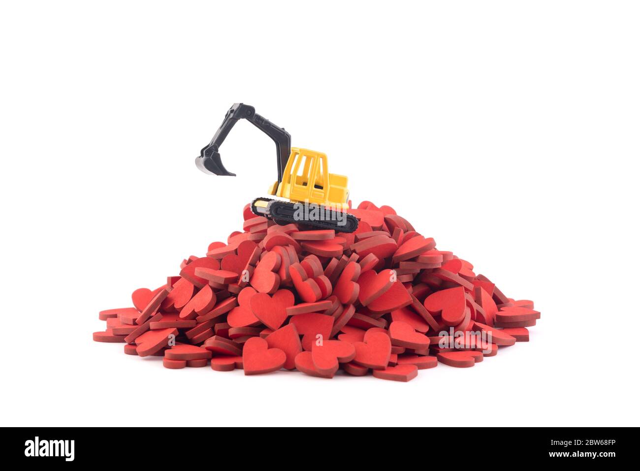 Excavator working on pile of hearts isolated on white background with clipping path Stock Photo