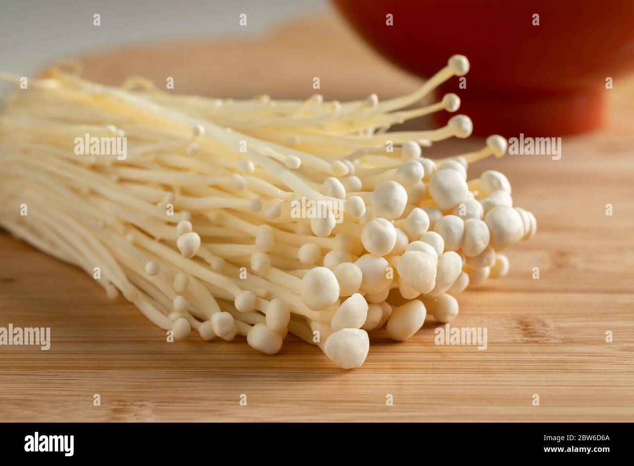 Cluster of fresh cultivated white enokii mushrooms close up Stock Photo