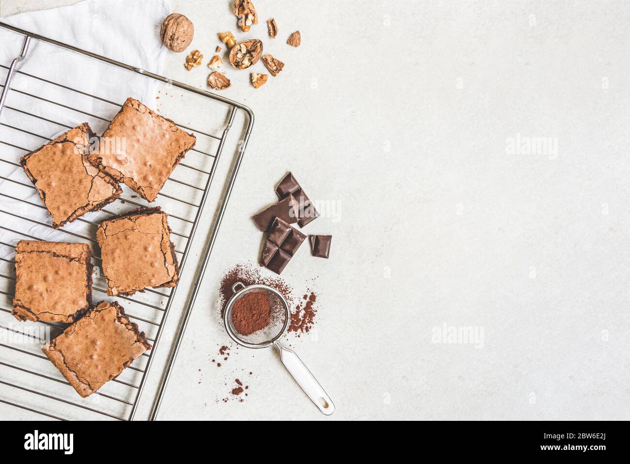 Top view of freshly baked home made brownie cake arranged with recipe ingredients over white rustic background. Copy space. Stock Photo