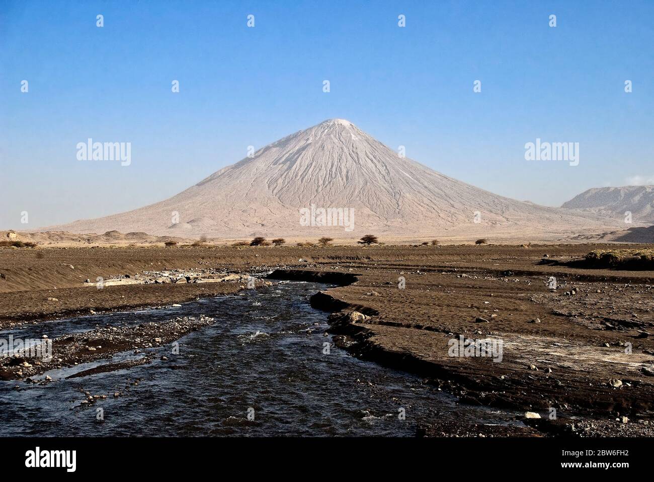 Ol Doinyio Lengai stratovolcano is the holy mountain of the Maasais people. Saitoti river in foreground. Stock Photo