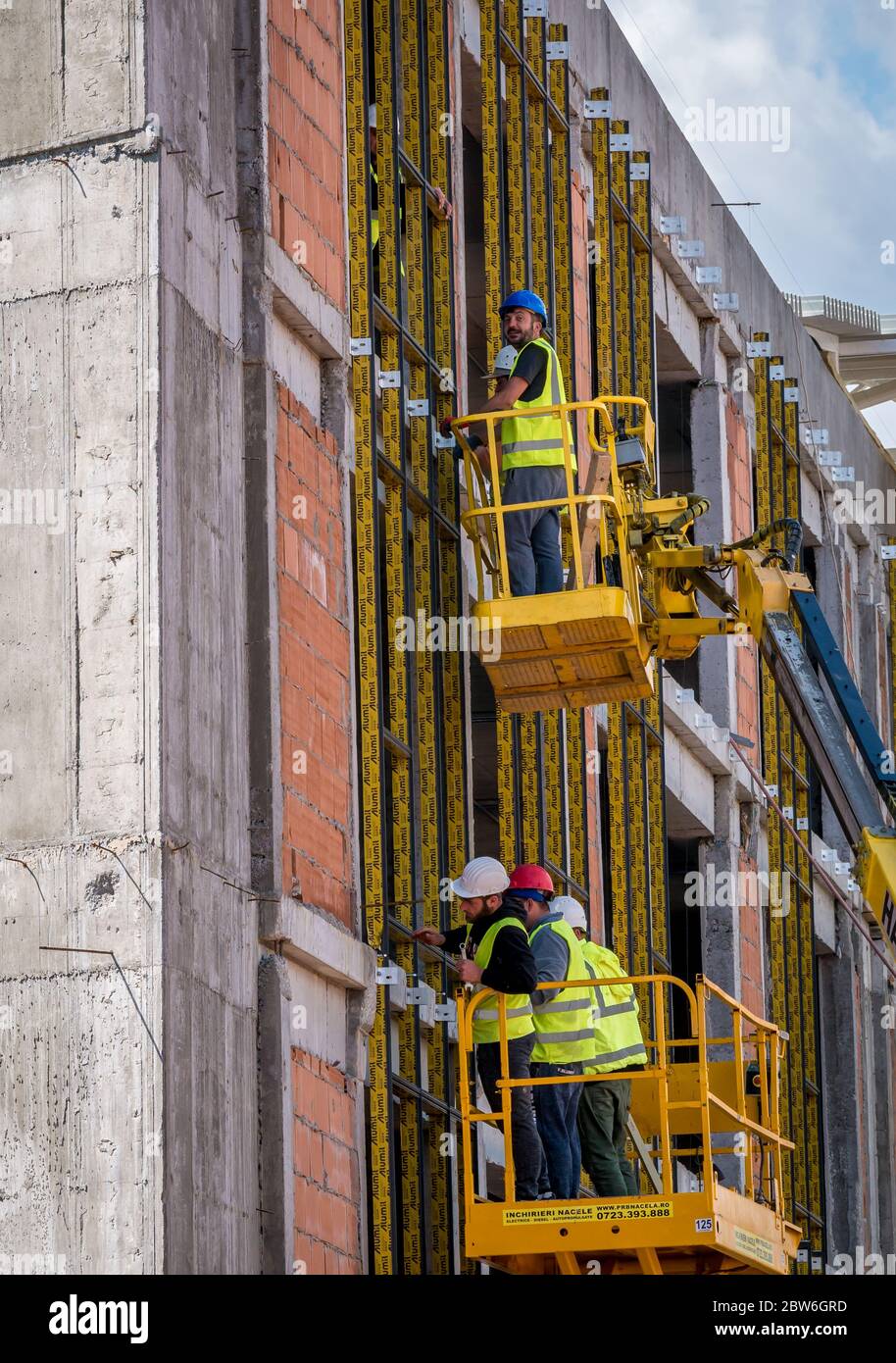 Bucharest/Romania - 05.16.2020: Construction workers on a scaffold. Men  working at a buildingfrom a hydraulic Lift table Platform Stock Photo -  Alamy