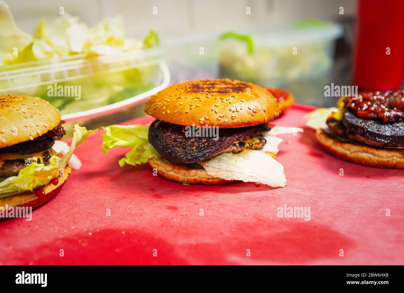 Fast food cooking in restaurant kitchen.Burgers with rare black blood ...