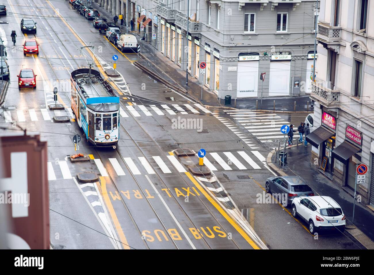 Milan. Italy - May 19, 2019: Street Panorama in Milan with Tram after Rain. Aerial View. Pedestrians and Cars on a Cloudy Day. Bus, Taxi and Tram Lane Stock Photo