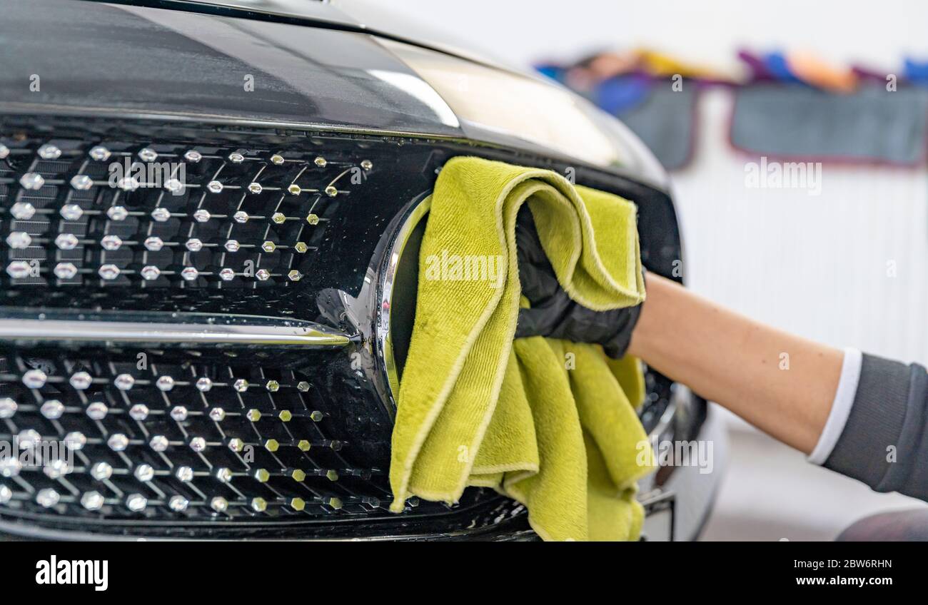 polishing the body of luxury cars with the help of a microfiber cloth