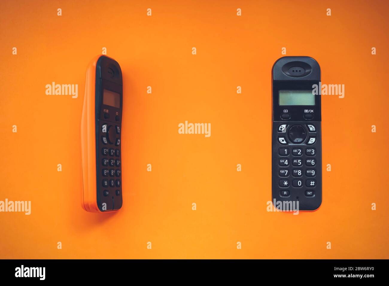 Two wireless cordless telephone, radiotelephone, dect cordless phone wireless phone, radiotelephone, radio phone on orange background Stock Photo