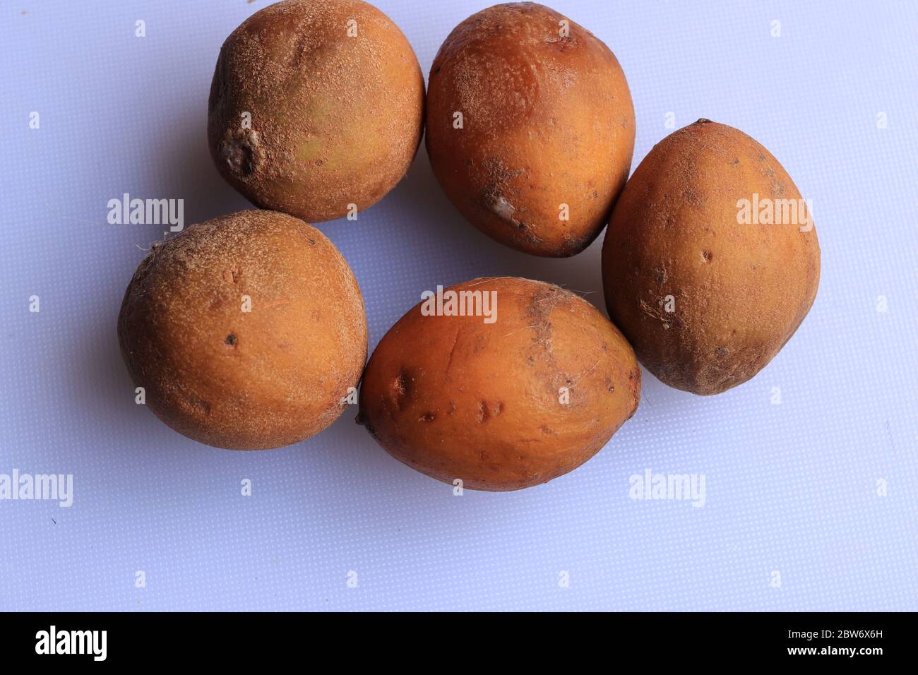 Ripe fresh sapota fruits isolated on white background Stock Photo