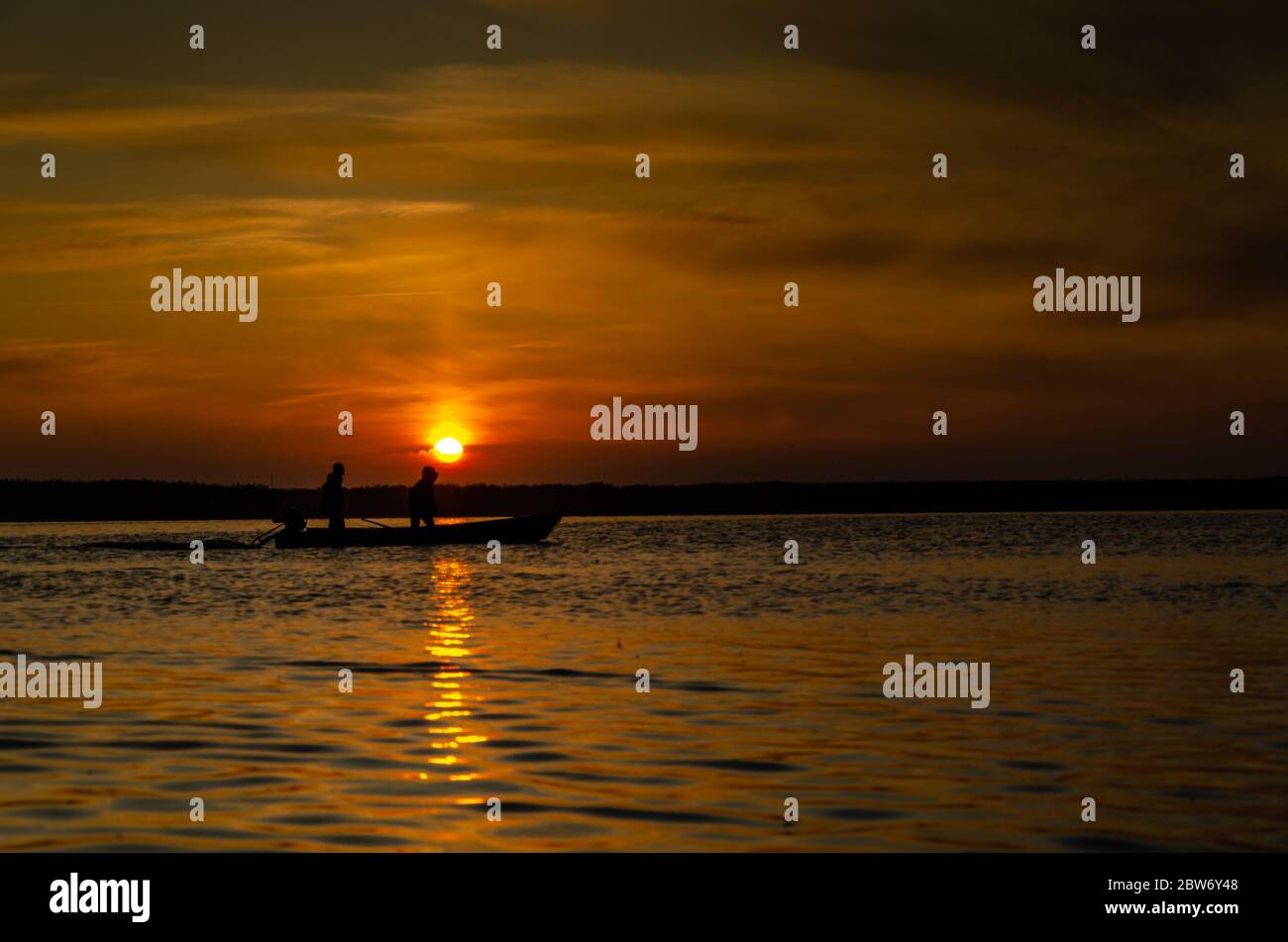 The fishermen and boat silhouette on the lake Stock Photo - Alamy